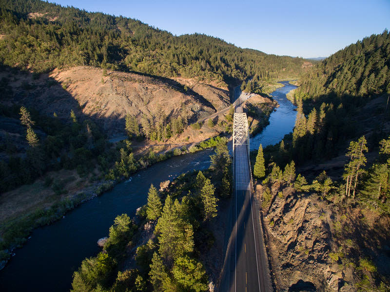 Aerial view of a river winding through a forested canyon